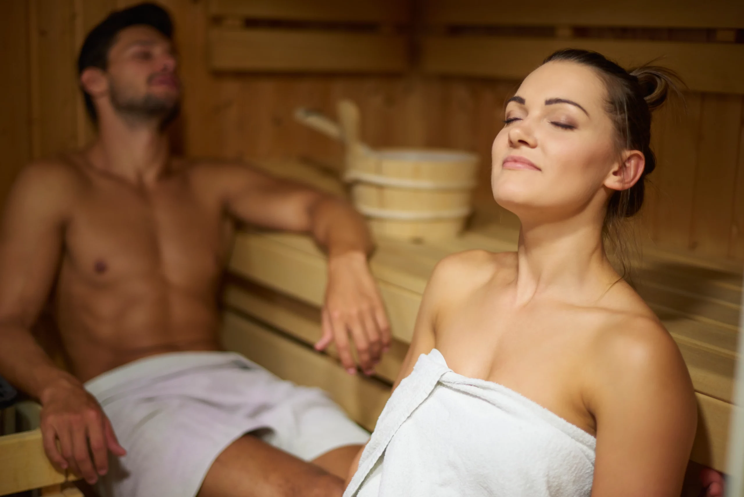 Zwei Personen entspannen in einer finnischen Sauna.